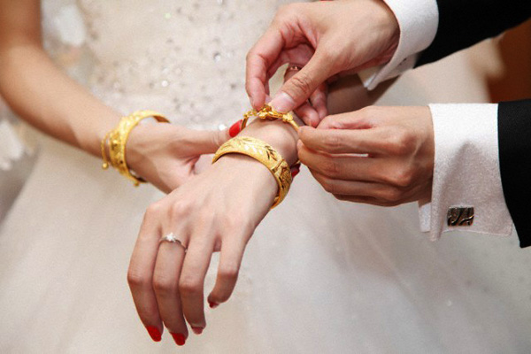 29 Sep 2012 --- Wearing a gold bracelet for the bride and groom --- Image by © Astock/Corbis